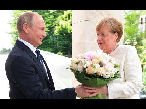 Путин вручает Меркель букет цветов